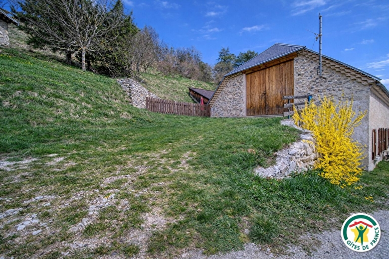 Parking possible dans la pente. Accès au jardin par le portillon en bois