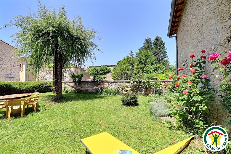Jardin clos, situé dans le hameau, attenant à la maison d'hôtes avec salon de jardin, bains de soleil et hamac